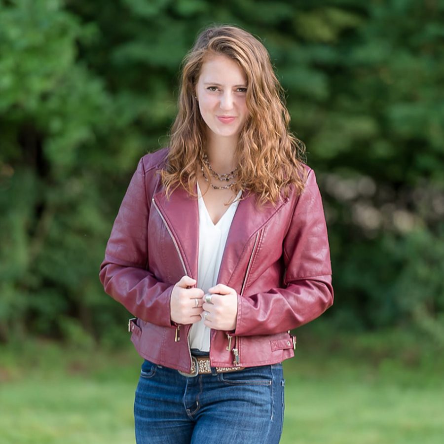 Caroline standing in a grassy field with a jacket on.