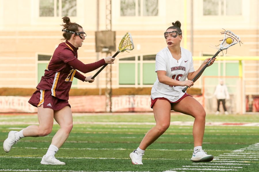 Senior+attacker+Olivia+Cunningham+challenges+a+defender+in+a+recent+rivalry+game+in+which+she+notched+her+100th+career+point.+%28Photo+courtesy+of+GoLeopards%29
