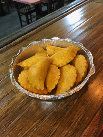 A tin foil container filled with empanadas.