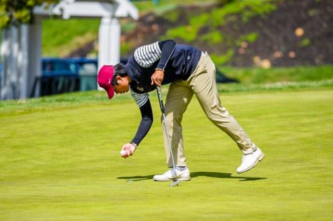Sophomore Sean Saw reaches down to spot his ball on the green during his top 40 finish at the UConn invitational. 
(Photo courtesy of GoLeopards)