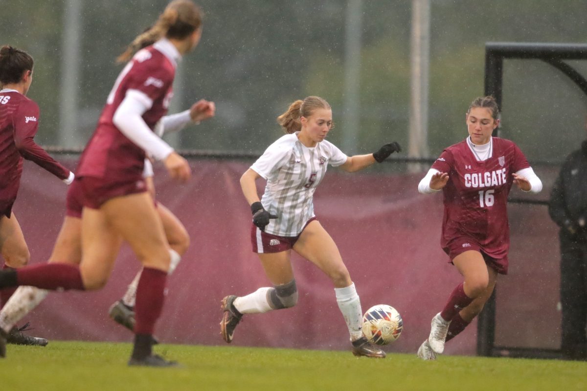 Senior defender Lauren Cunningham threads the needle between two defenders during the Leopards win over Colgate. (Photo by Rick Smith for GoLeopards)