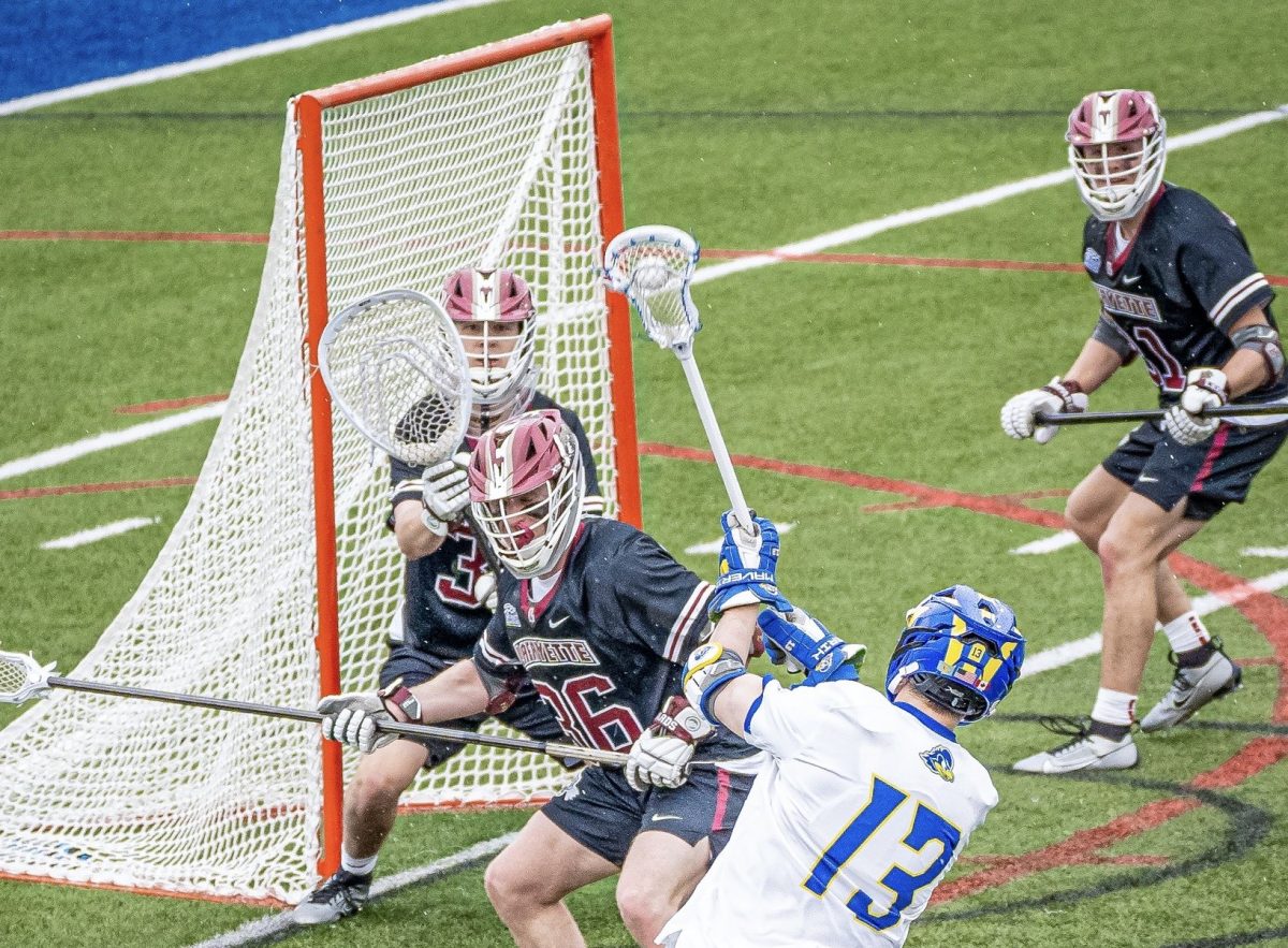 Senior Tommy McGee defends a Blue Hen shot on goal. (Photo courtesy of @DelawareMLAX on X)
