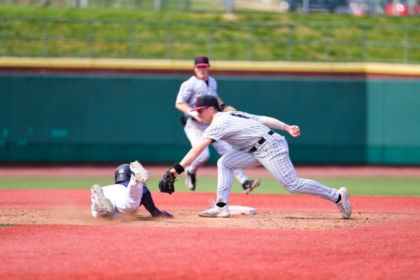 Freshman utility Luke Caucci tries to tag out a Navy baserunner. (Photo by Hannah Ally for GoLeopards)