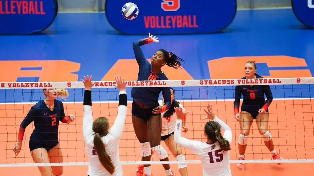 Senior outside hitter Abby Nieporte and junior middle blocker Hannah Ehrich-Pollock go up to block a Syracuse player. (Photo courtesy of Syracuse University Athletics)