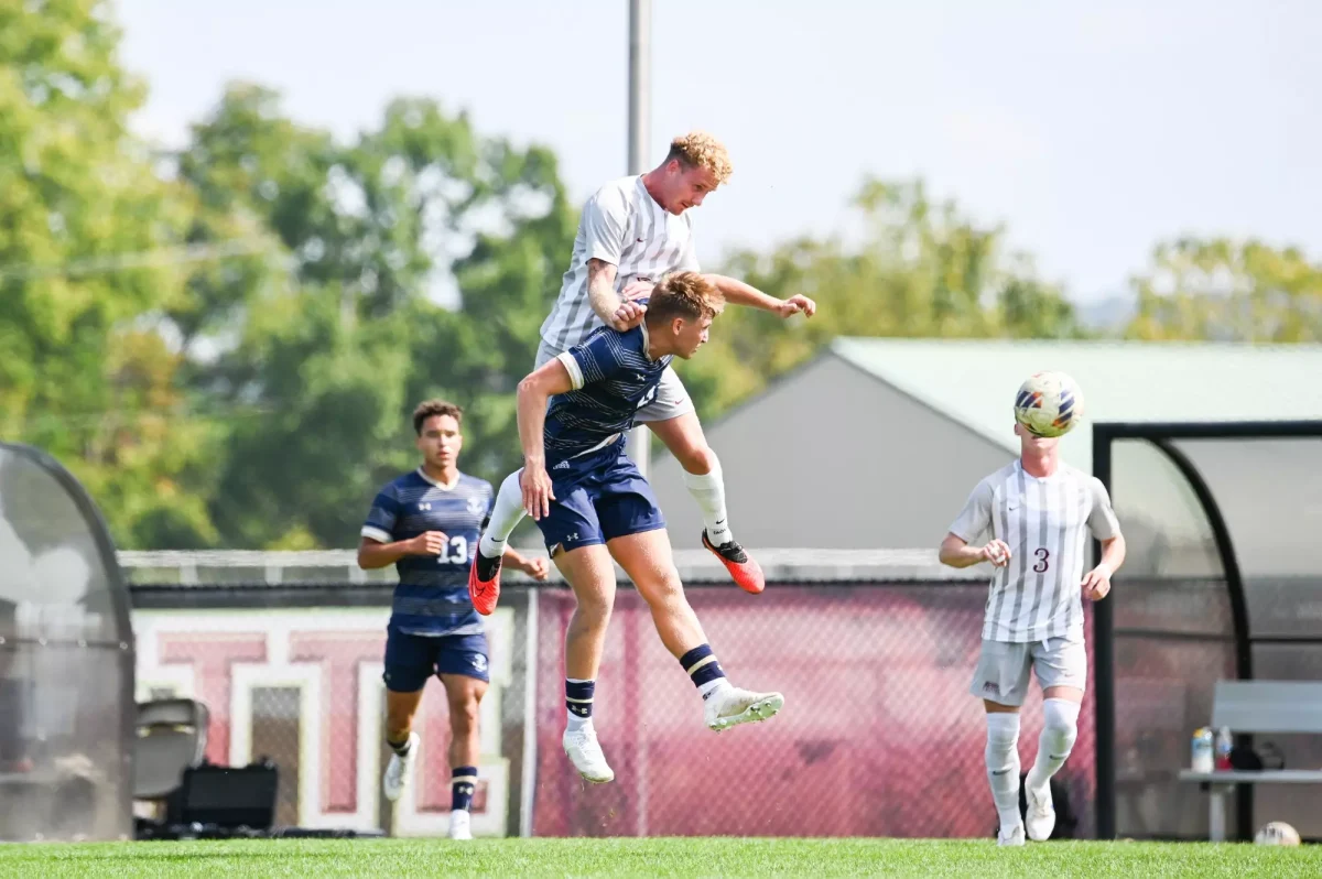 Senior midfielder Digger Iqbal leaps over a Navy defender for a header on Saturday. (Photo by George Varkanis for GoLeopards)