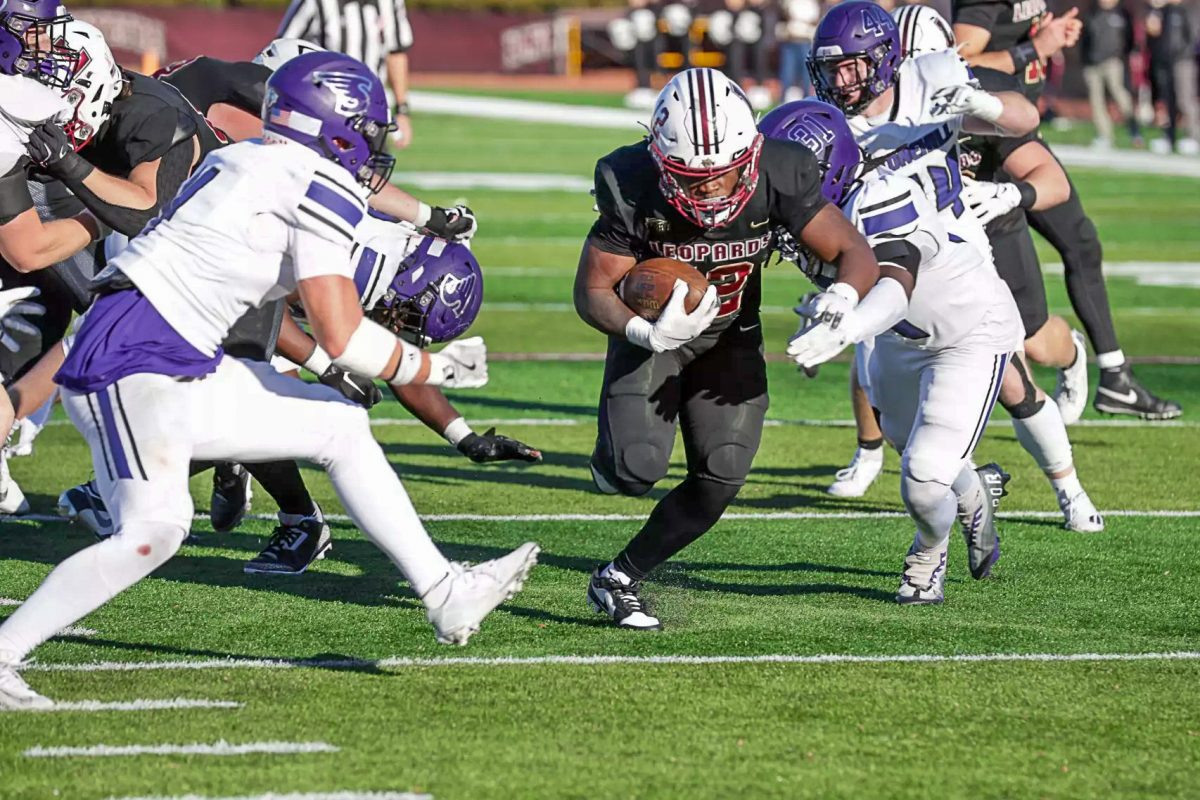 Sophomore running back Troy Bruce bursts through a hole in the Stonehill defense. (Photo by Rick Smith for GoLeopards)