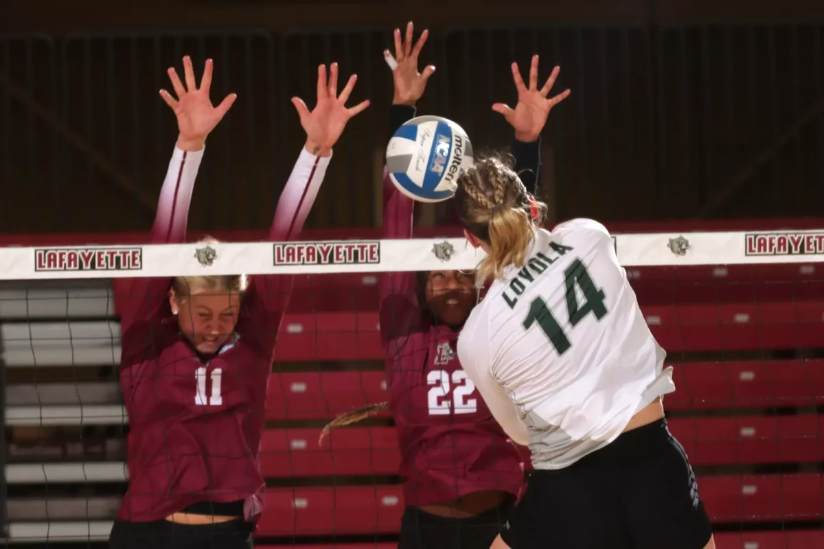 Sophomore middle blocker Irelynd Lorenzen and freshman outside hitter Destiny McKenzie go up for a block against Loyola University Maryland. (Photo by Rick Smith for GoLeopards)