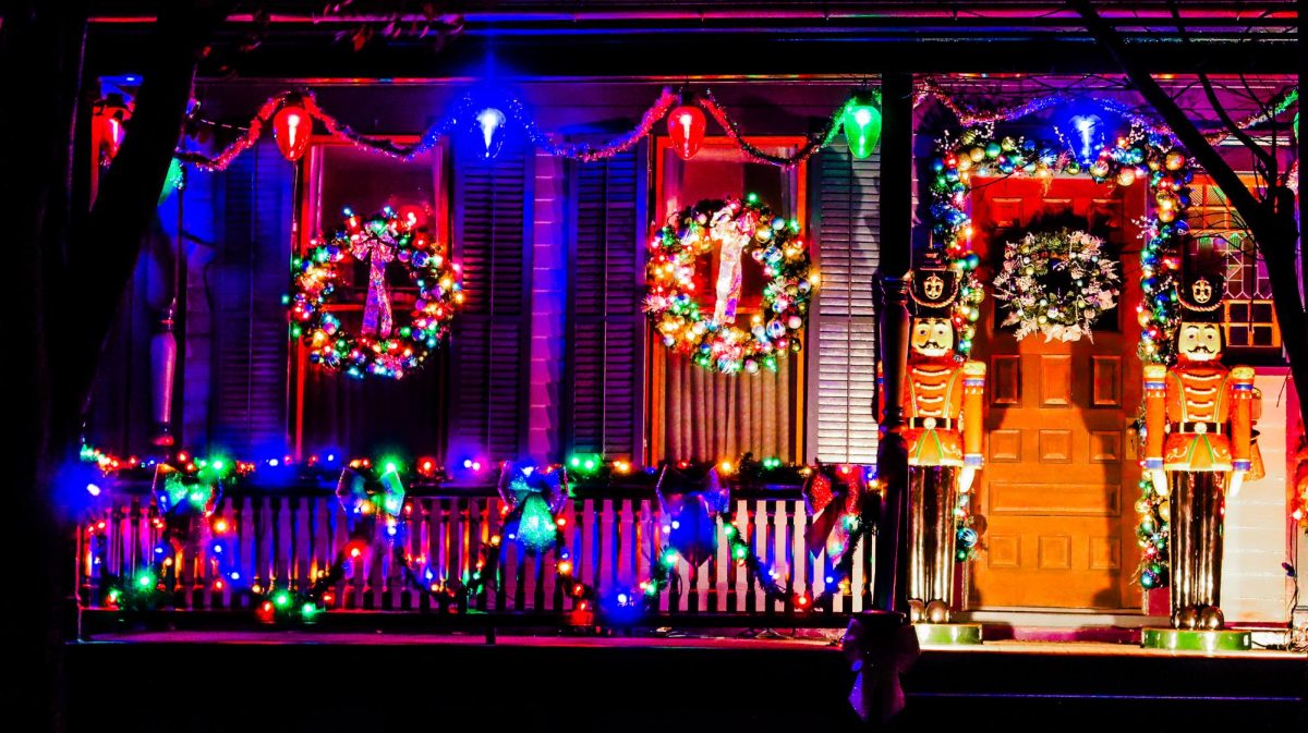 Colorful wreaths and a life-sized nutcracker decorate a porch.