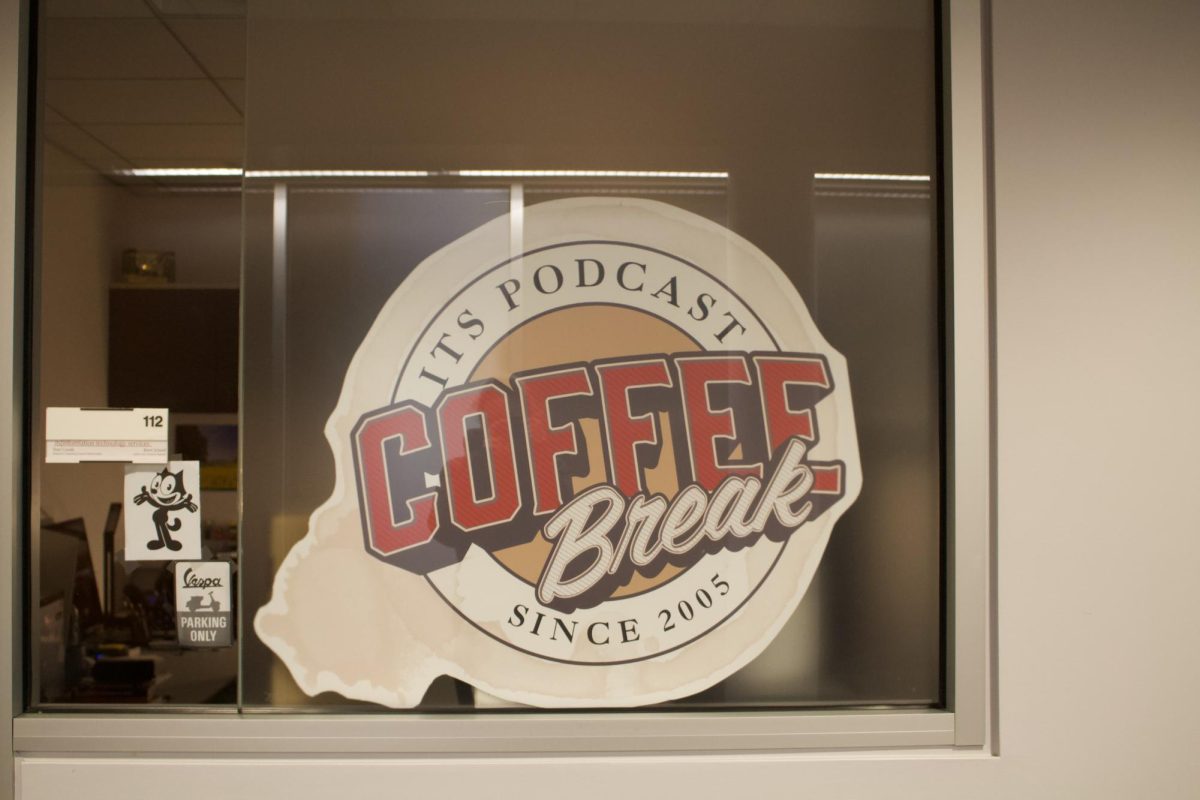 A sign for "Coffee Break" sits in the window of the podcast editing room in Skillman Library.