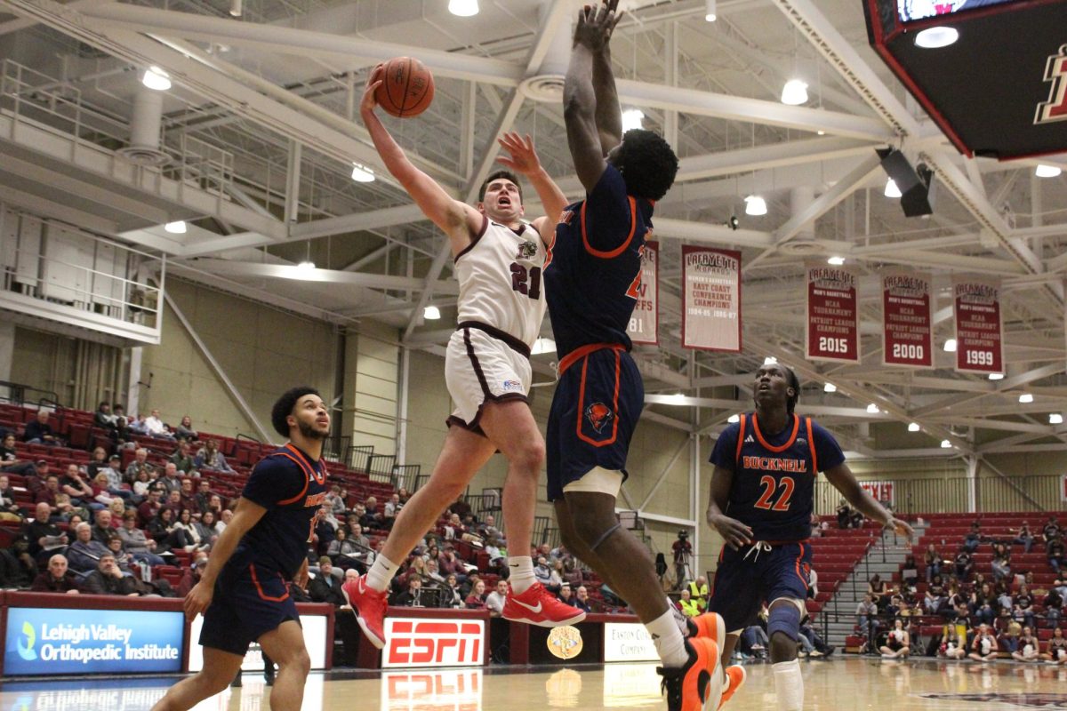 Sophomore guard Andrew Phillips looks to finish through contact against Bucknell University. 